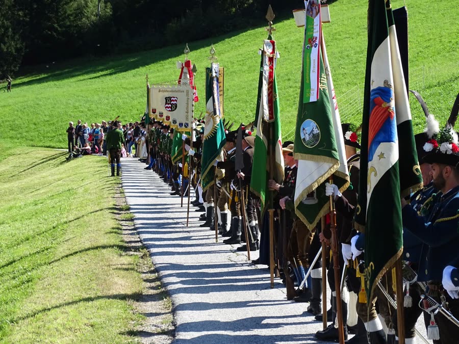 Fahnenabordnung der Senseler Schützenkompanie bei der Waldermesse am Großvolderberg, umgeben von grüner Wiese